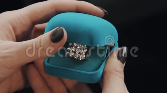 女性手打开蓝色天鹅绒首饰盒取出钻石戒指视频的预览图