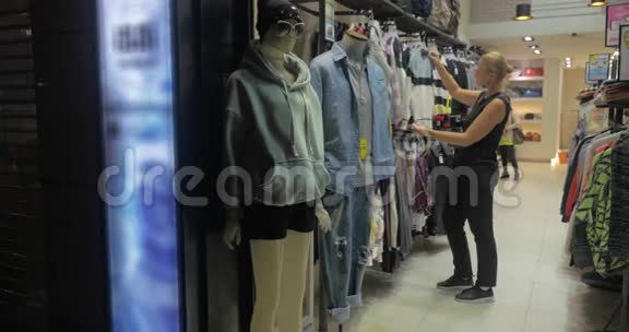 中国香港在店里挑选衬衫时金发女郎微笑着视频的预览图
