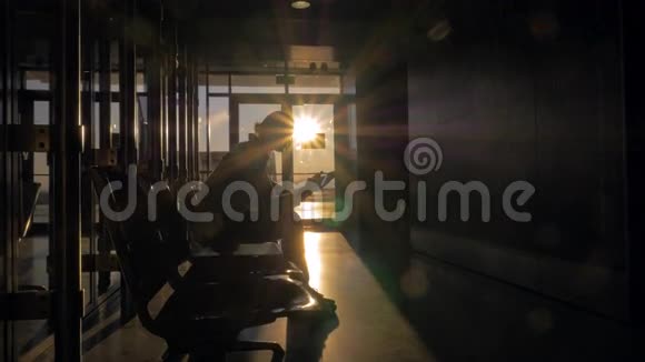 日落时分母亲和儿子坐在机场候机楼视频的预览图