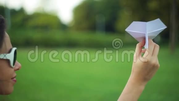公园里拿着纸飞机的女人视频的预览图