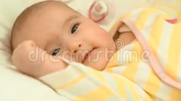 小刚出生的婴儿在婴儿床上可爱而微笑视频的预览图