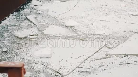 寒冷的冬日冰封的湖面上覆盖着积雪的生锈的金属堤岸视频的预览图