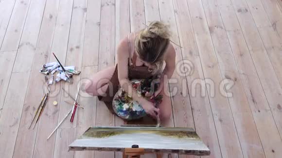 艺术家女画杰作坐在地板上顶部视图视频的预览图