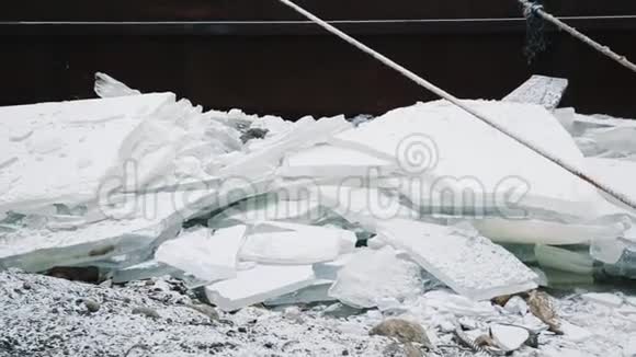 冻湖岸上生锈的金属码头下的碎冰堆视频的预览图