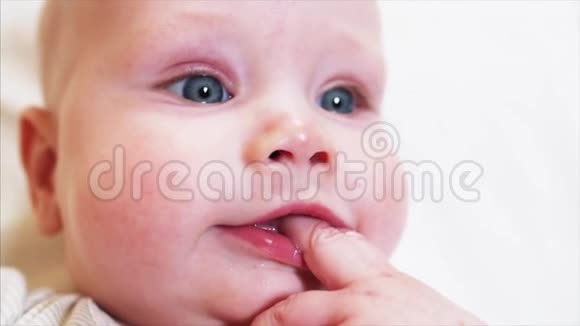 小男孩吮吸或咀嚼他的小手指看着镜头后面的人视频的预览图