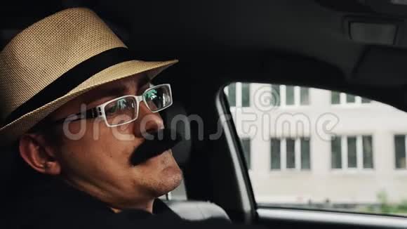 戴着胡子戴着帽子的人戴着眼镜坐在车窗前唱歌仿造视频的预览图