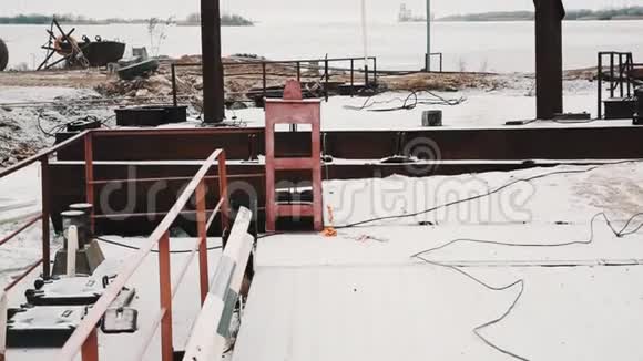 冰封的湖岸锈迹斑斑的码头被雪覆盖被毁的建筑视频的预览图