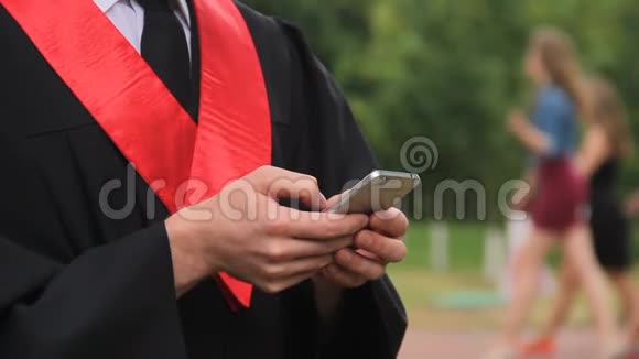 毕业生在智能手机上观看毕业典礼的照片视频的预览图