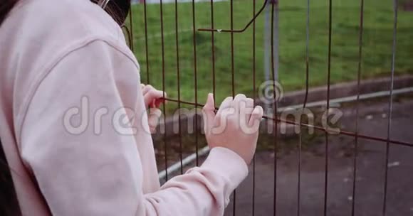 儿童手握金属生锈栅栏的细节慢动作视频4k红色史诗视频的预览图