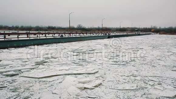 冰雪覆盖的冰封河面上的金属渡船桥视频的预览图
