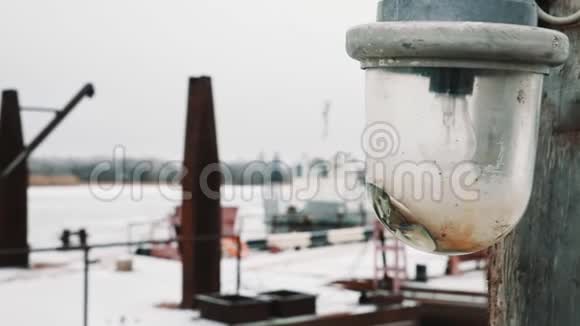 冻湖岸边船上生锈码头上的大型灯泡玻璃灯视频的预览图