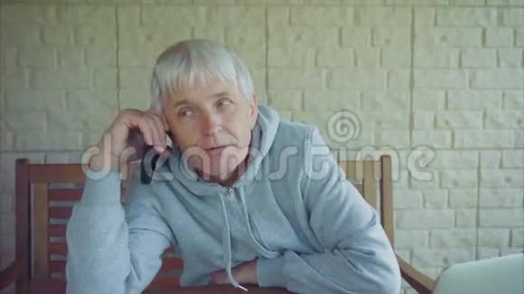 一位白发苍苍的老白种人在用手机说话视频的预览图