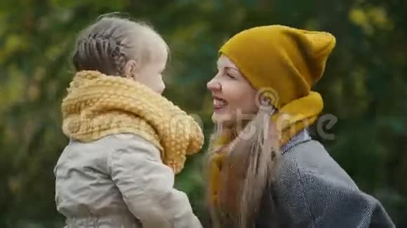 金发小女孩和妈妈一起在秋天的公园里玩拍拍手关门视频的预览图