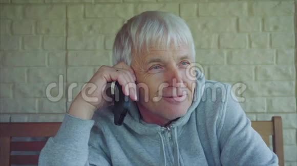 一位白发苍苍的老白种人在用手机说话视频的预览图