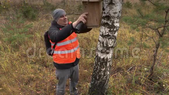 鸟类学家森林中桦树附近有鸟巢箱视频的预览图