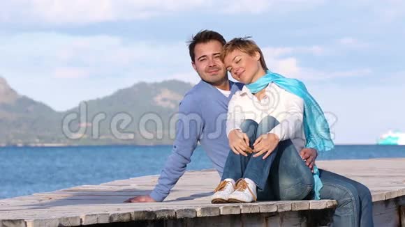 年轻夫妇坐在码头上视频的预览图