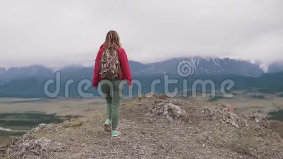 一个带背包的年轻女游客的肖像背面视图视频的预览图