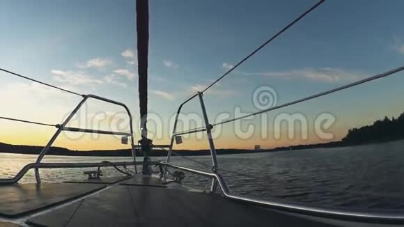日落时美丽的水景船头部分帆船溅起浪花视频的预览图