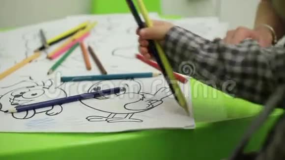 儿童手中的彩色书和铅笔视频的预览图