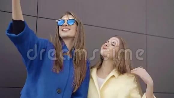 两个穿着外套和太阳镜自拍的时髦女孩4K视频的预览图