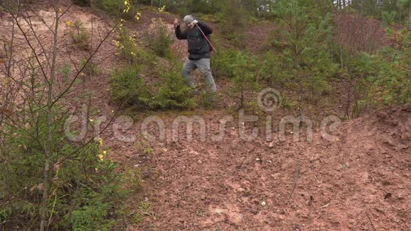 徒步旅行者从森林的斜坡上下来视频的预览图