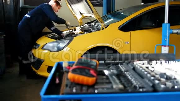 机械师修理一辆汽车拧开汽车的细节车库服务视频的预览图