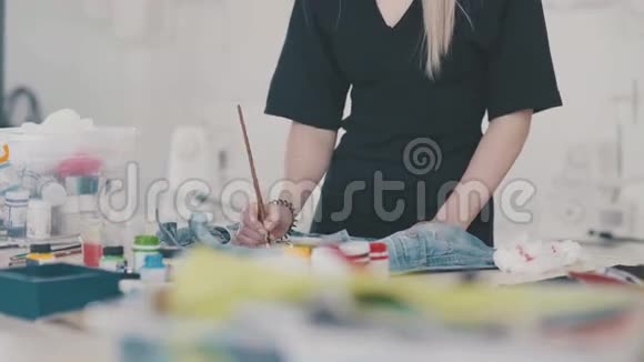 女设计师用特殊的颜料和画笔在织物上作画视频的预览图