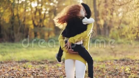 快乐的年轻母亲和她的小红发女儿在秋天的公园里玩得很开心他们玩拥抱笑视频的预览图