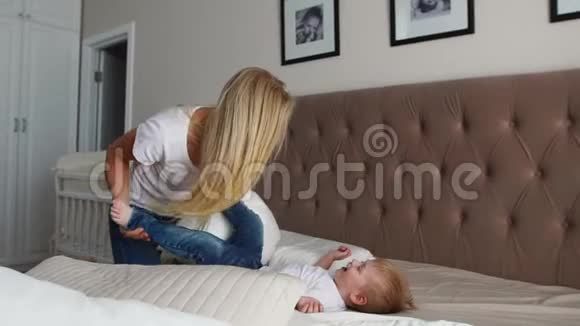 父母和他们的小女儿在床上玩家庭在早晨的时间视频的预览图