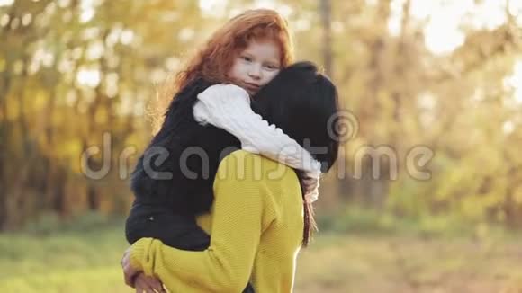快乐的年轻母亲和她的小红发女儿在秋天的公园里玩得很开心他们玩拥抱笑视频的预览图