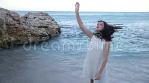 穿着白色裙子的漂亮女孩站在海滨希腊视频的预览图