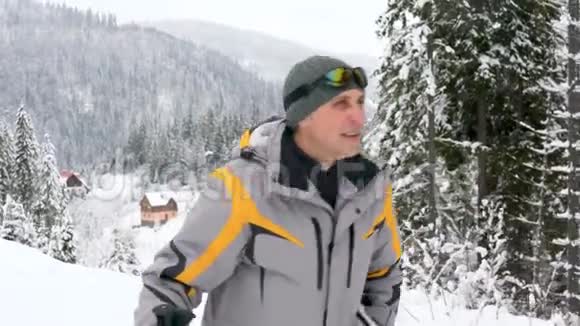 一个手里拿着滑雪板的人站起来准备下山视频的预览图