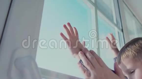 儿童的手触摸一扇窗户躺在成人的手上视频的预览图
