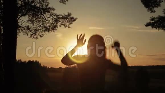 日落时分年轻快乐的女人在森林里跳跃跳舞和玩耍视频的预览图