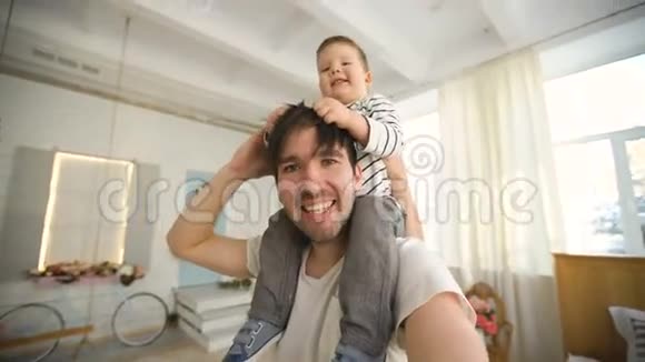 快乐的父亲带着他微笑的儿子在脖子上在卧室视频的预览图