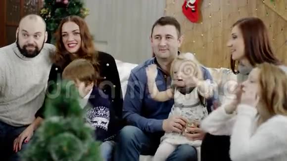 圣诞晚会上幸福家庭在镜头前挥手的侧视图视频的预览图