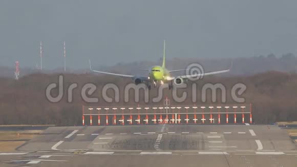 美丽的黄绿色客机降落在机场的跑道上视频的预览图