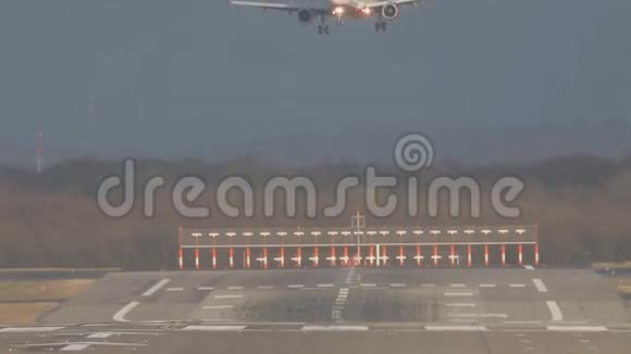 白色客机在机场跑道上缓慢降落视频的预览图