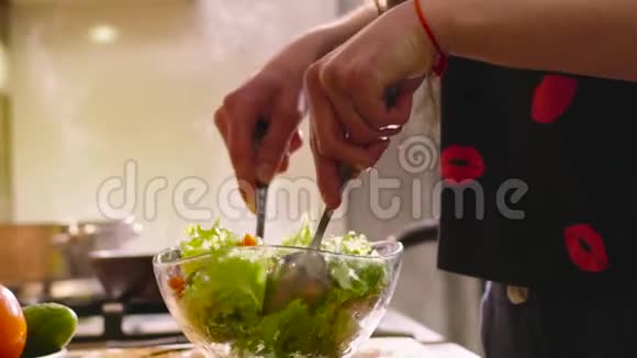 一个穿着睡衣的年轻黑发女人正在厨房做饭她做了一些新鲜的沙拉里面有青莴苣黄瓜和视频的预览图