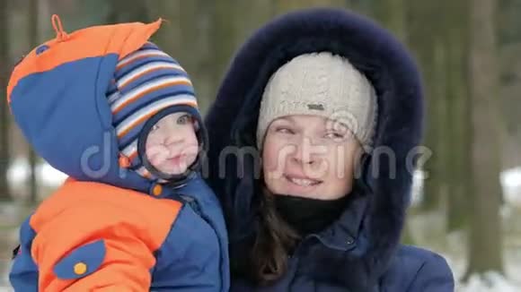 可爱的宝宝在冬天妈妈的怀里他们谈笑风生两人都穿着温暖的蓝色和橙色这就是视频的预览图