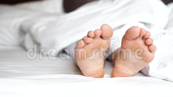 精致的雌性脚在白色床上嬉戏地移动脚趾视频的预览图