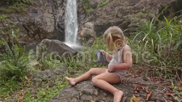 为瀑布穿泳装特写小女孩隐藏电话视频的预览图