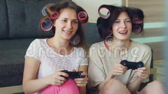 两个有趣的女人用游戏本玩游戏机在家玩得很开心视频的预览图
