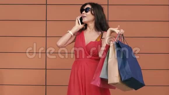 快乐的年轻女人带着购物袋对她的购物日感到兴奋慢动作视频的预览图