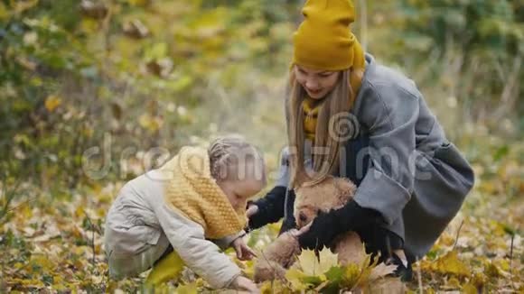 妈妈花时间和女儿在秋天公园散步收集树叶关门视频的预览图