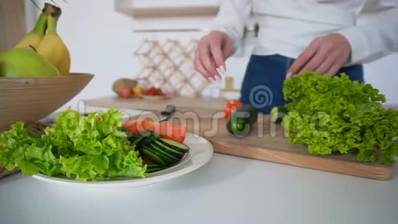 在轻厨房里用砧板准备健康午餐的美女的手的特写镜头视频的预览图