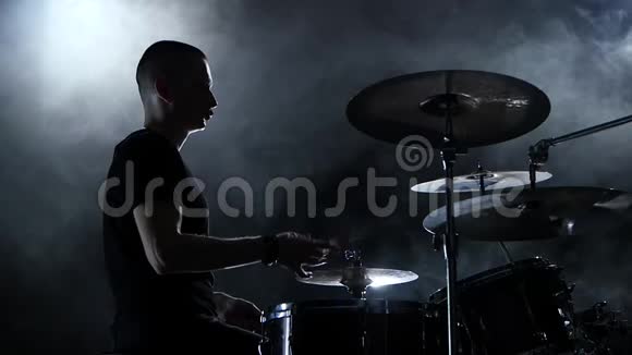 鼓手在鼓上演奏充满活力的音乐黑色背景侧视慢动作视频的预览图
