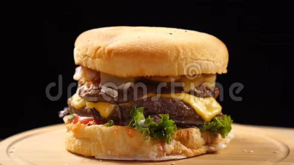 新鲜多汁的汉堡包在黑色背景上旋转视频的预览图