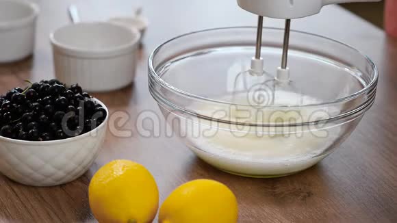 女人用搅拌器把蛋清搅拌到玻璃碗里视频的预览图