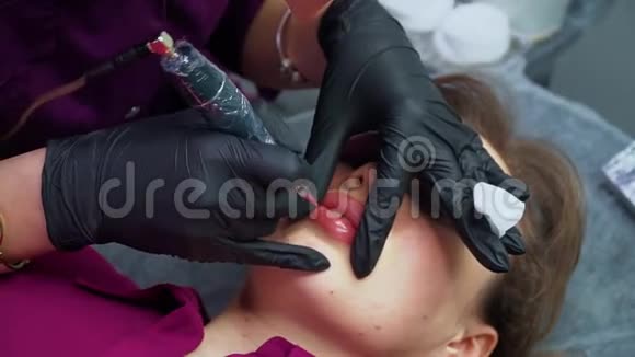 永久化妆美容师在嘴唇上涂永久性化妆品视频的预览图
